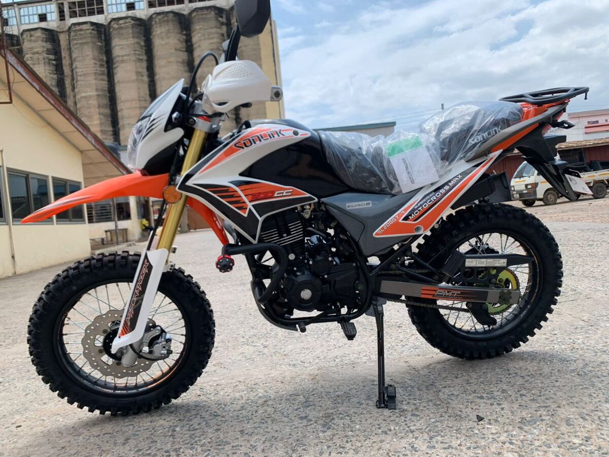 Orange and black Apsonic trail bike in the yard